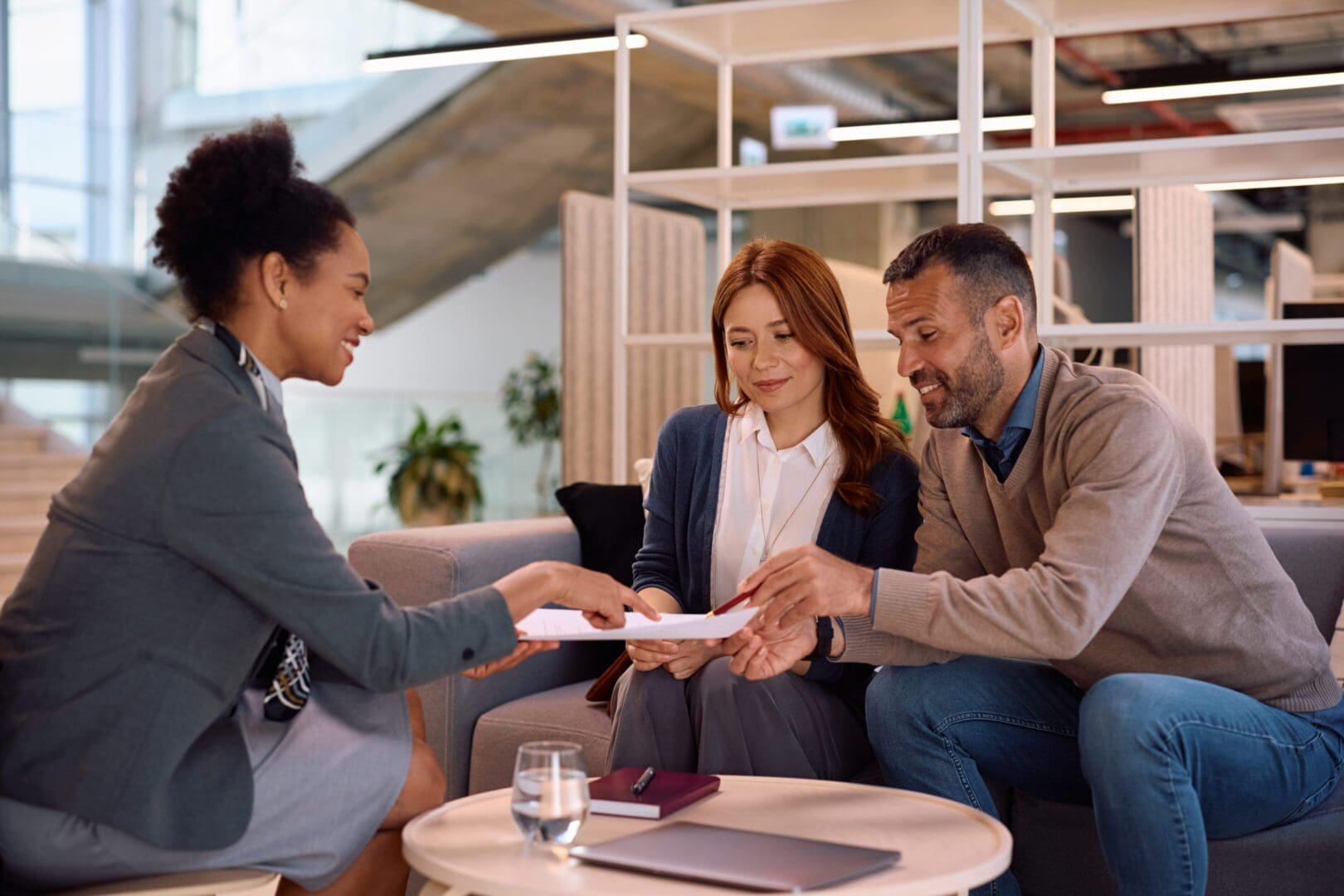 People discussing documents in modern office setting.