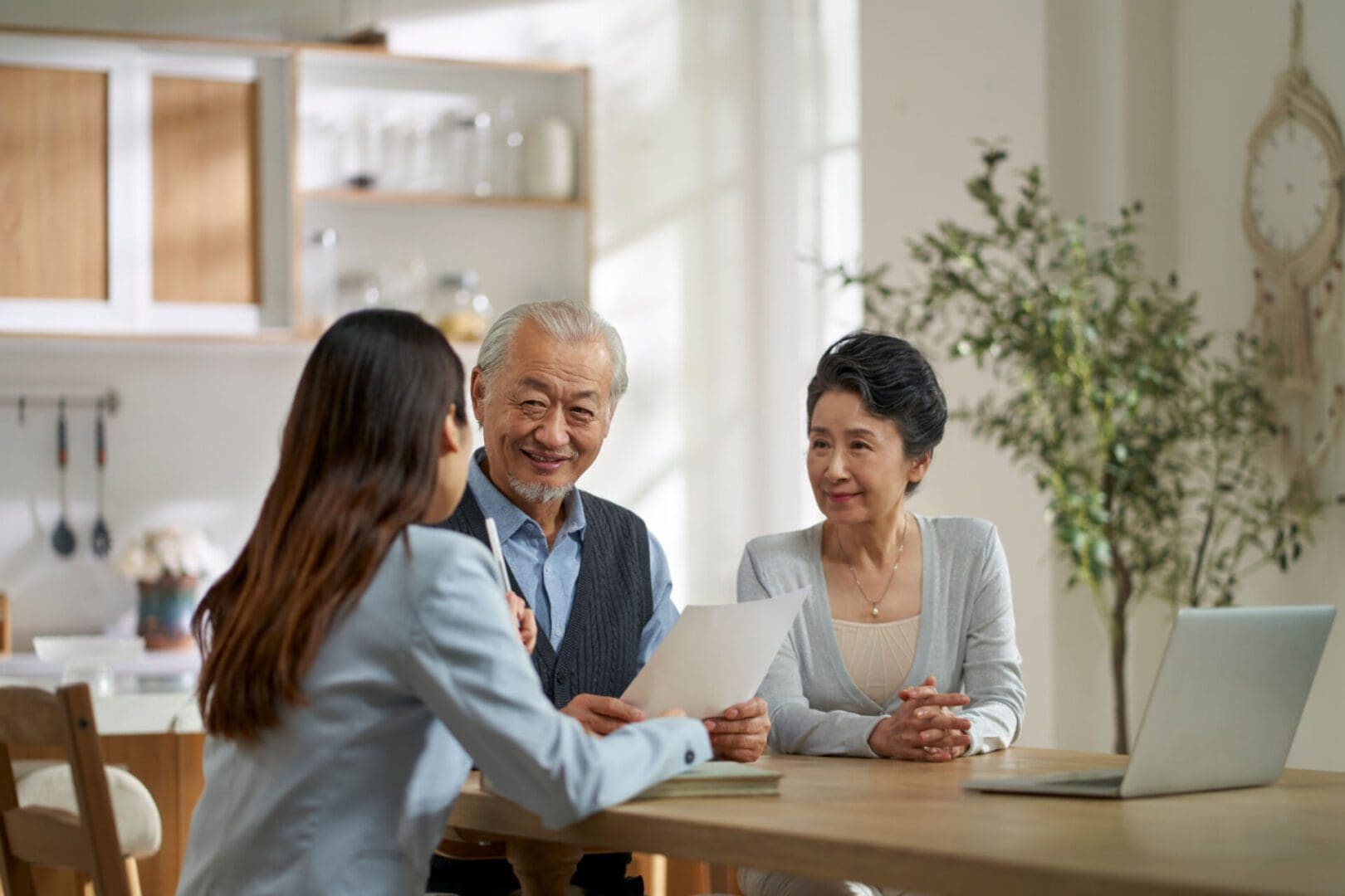 Three people discussing documents at table.