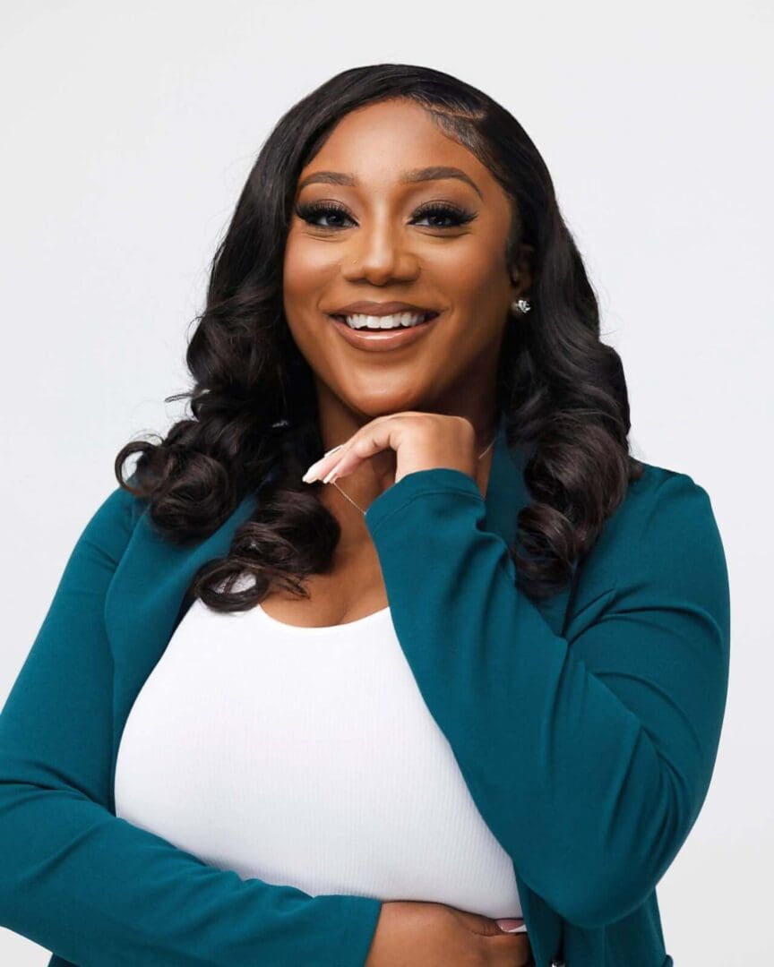 Smiling woman in teal blazer, confident pose.